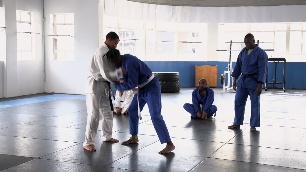 Practicing judo, athletes in dojo performing throws and grappling techniques
