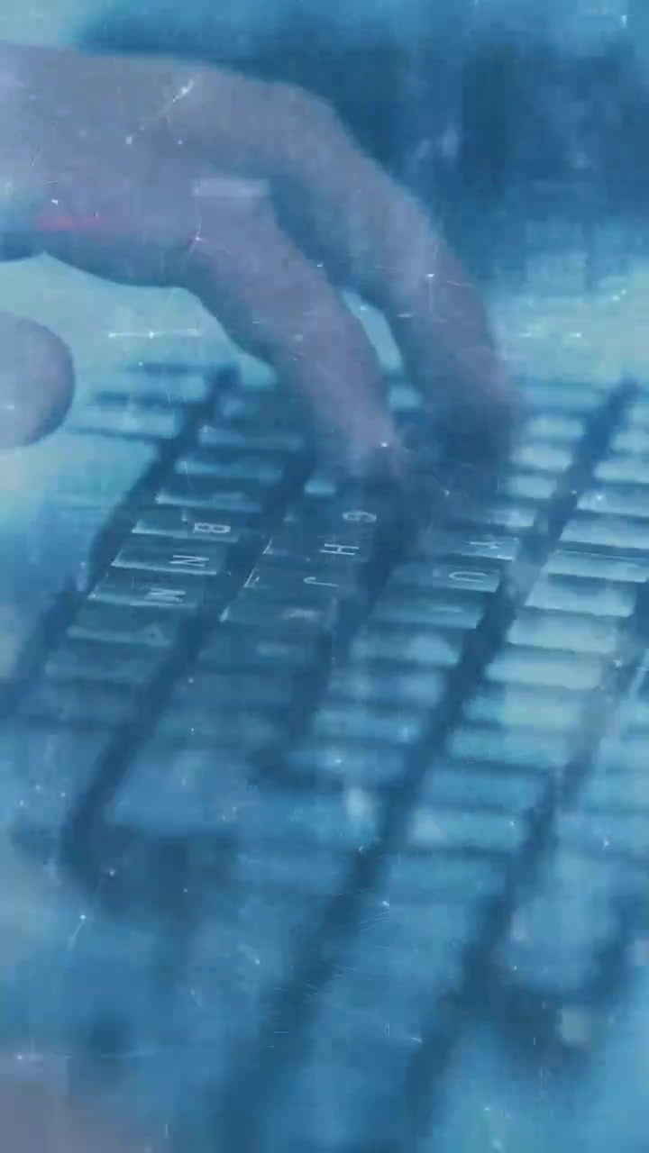 Video verticale: Mani che si avvicinano ai tasti iniziando a digitare costantemente, sovrimpressione che mostra attività di cybersecurity