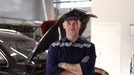 Portrait-of-a-smiling-mechanic-repairing-in-uniform-standing-looking-camera