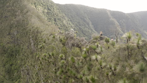 4k drone shot of hikers sitting and resting on a beautiful mountain spine cliff at border ranges national park, new south wales australia