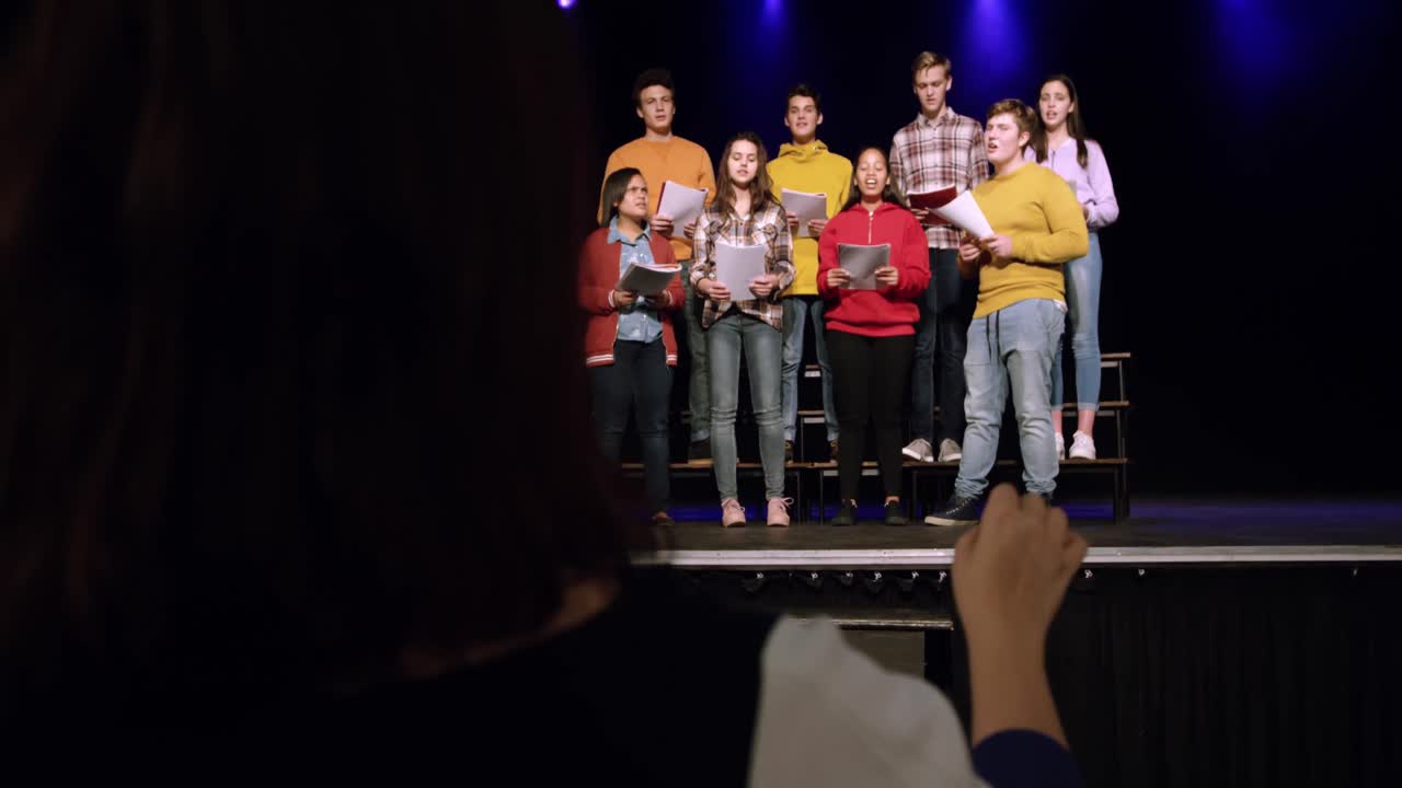 adolescentes ensayando en un teatro
