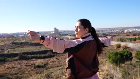 corredora disfruta de la luz del sol, abriendo su chaqueta y estirando los brazos en la naturaleza