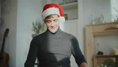 man wearing santa cap while sorting glowing lights