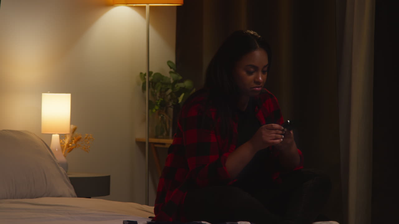 Woman Texting on Phone in Bedroom at Night