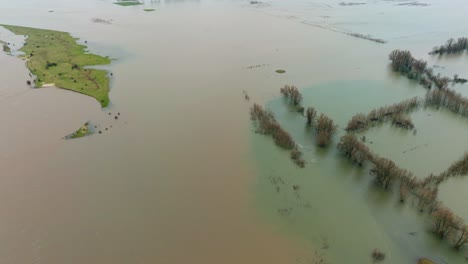 Vista-Aérea-De-Granjas-Y-Comunidades-Inundadas-A-Lo-Largo-Del-Río-Waal-Cerca-De-Rotterdam,-Países-Bajos,-Mientras-Fuertes-Tormentas-Azotan-La-Zona