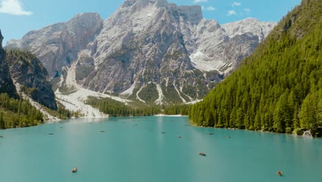 Toma-Aérea-De-Un-Dron-Sobre-El-Río-Con-Los-Alpes-Dolomitas-En-La-Espalda,-Lago-Di-Braies,-Italia,-Dolomitas