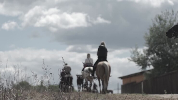 Gruppo di persone a cavallo in campagna