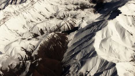 Luftaufnahme-Aus-Dem-Flugzeugfenster,-Das-über-Die-Schneebedeckte-Iranische-Berglandschaft-In-Der-Wüste-Im-Nahen-Osten-Fliegt