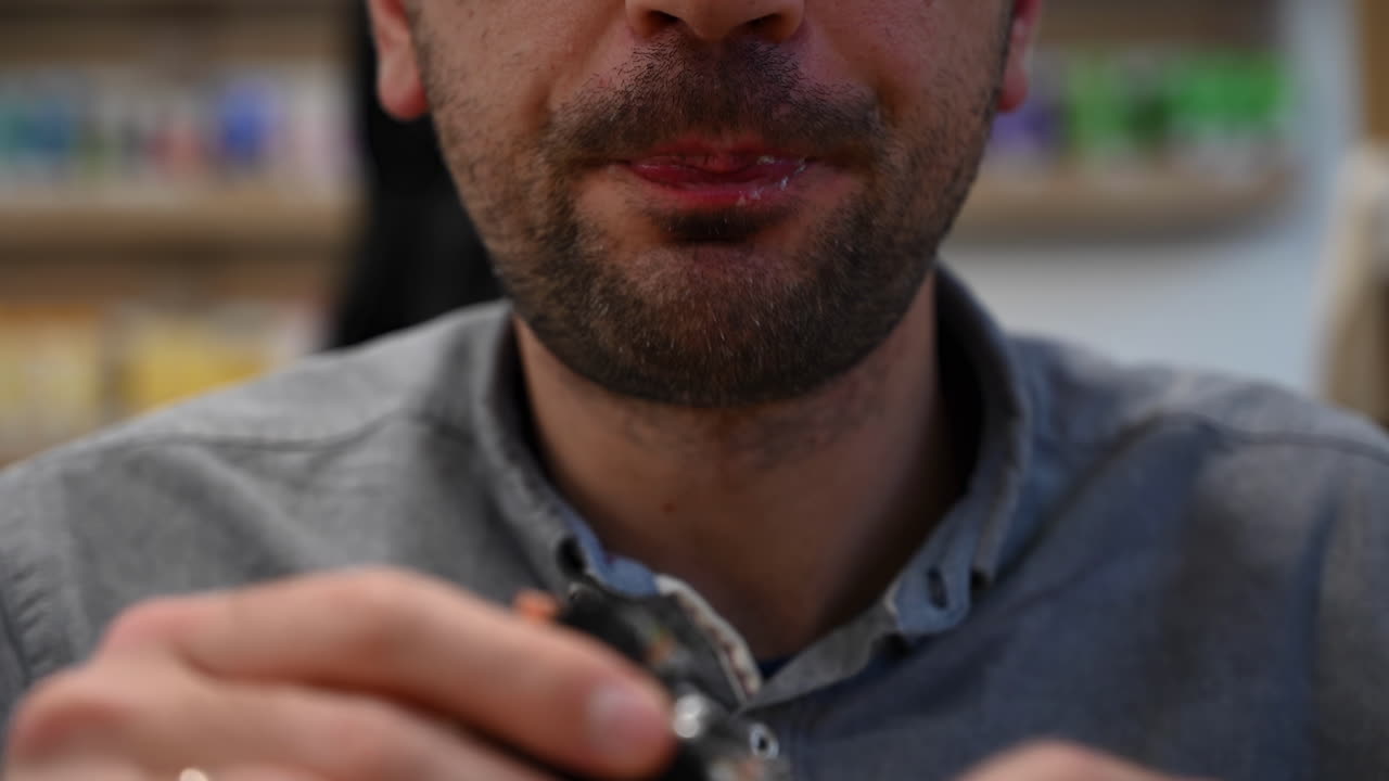 Close up of a man eating a burger with black buns