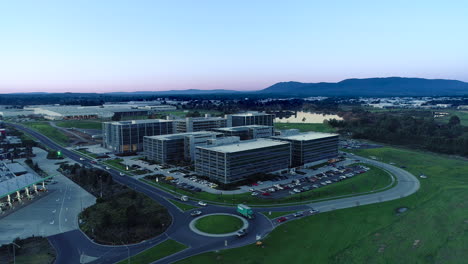 Trucks-and-cars-entering-round-about-to-commute-toward-their-final-destination-beside-modern-business-park-facilities