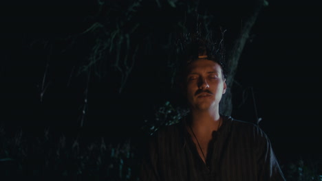 man with branch headpiece in a night ritual