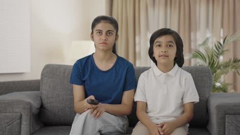 hermanos indios viendo la televisión en casa