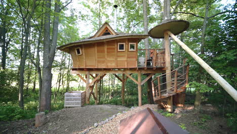 zoom out fhd shot of a luxurious wooden tree house accommodation at an outdoor campsite in a forest in dolní morava, czech republic