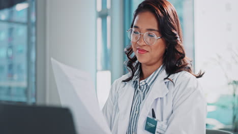 a female doctor reviews medical documents in her office