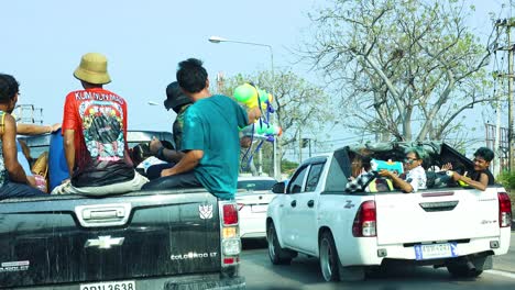 people enjoying water fights from pickup trucks