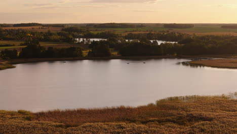 serene sunset lake landscape with boats and rural scenery