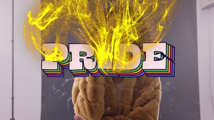 Woman adjusting shades and opening arms, causing PRIDE graphic for Pride while yellow smoke flows