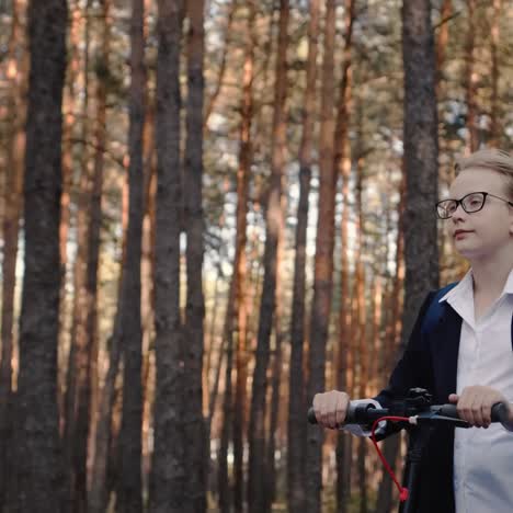 schoolgirl rides a scooter in a park with tall trees