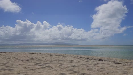 Time-lapse-sequence-from-a-beach,-showcases-oceanic-currents-and-drifting-cloudscapes