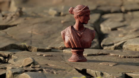 ancient-statue-of-woman-on-rocky-stones
