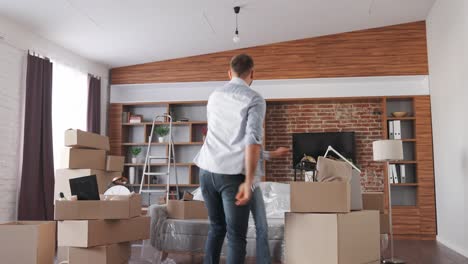 happy homeowners dancing and having fun on relocation day. young couple moving into new apartment. new accommodation or rented flat. real estate and tenancy concept. loan mortgage for young family.