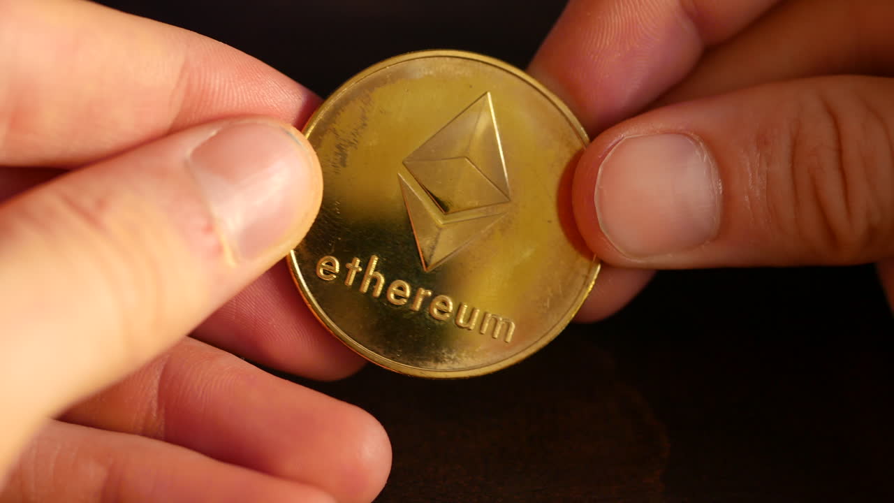 Ethereum cryptocurrency coin in hand shining in the light