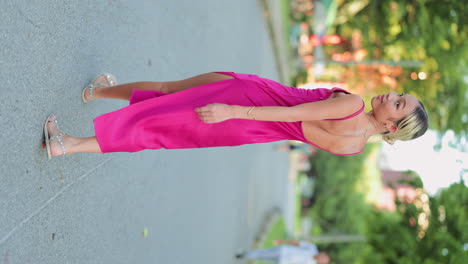 Woman in a Vibrant Pink Backless Dress Walking Outdoors