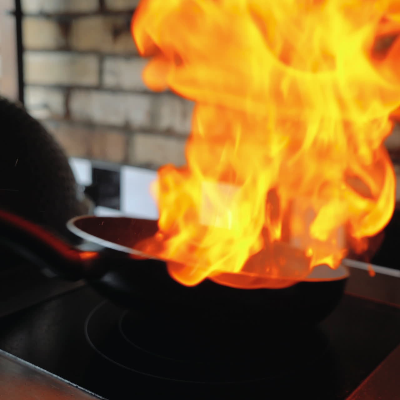 Chef sautes mushrooms with flames in restaurant while flipping around food. Professional cooking. Sqare video