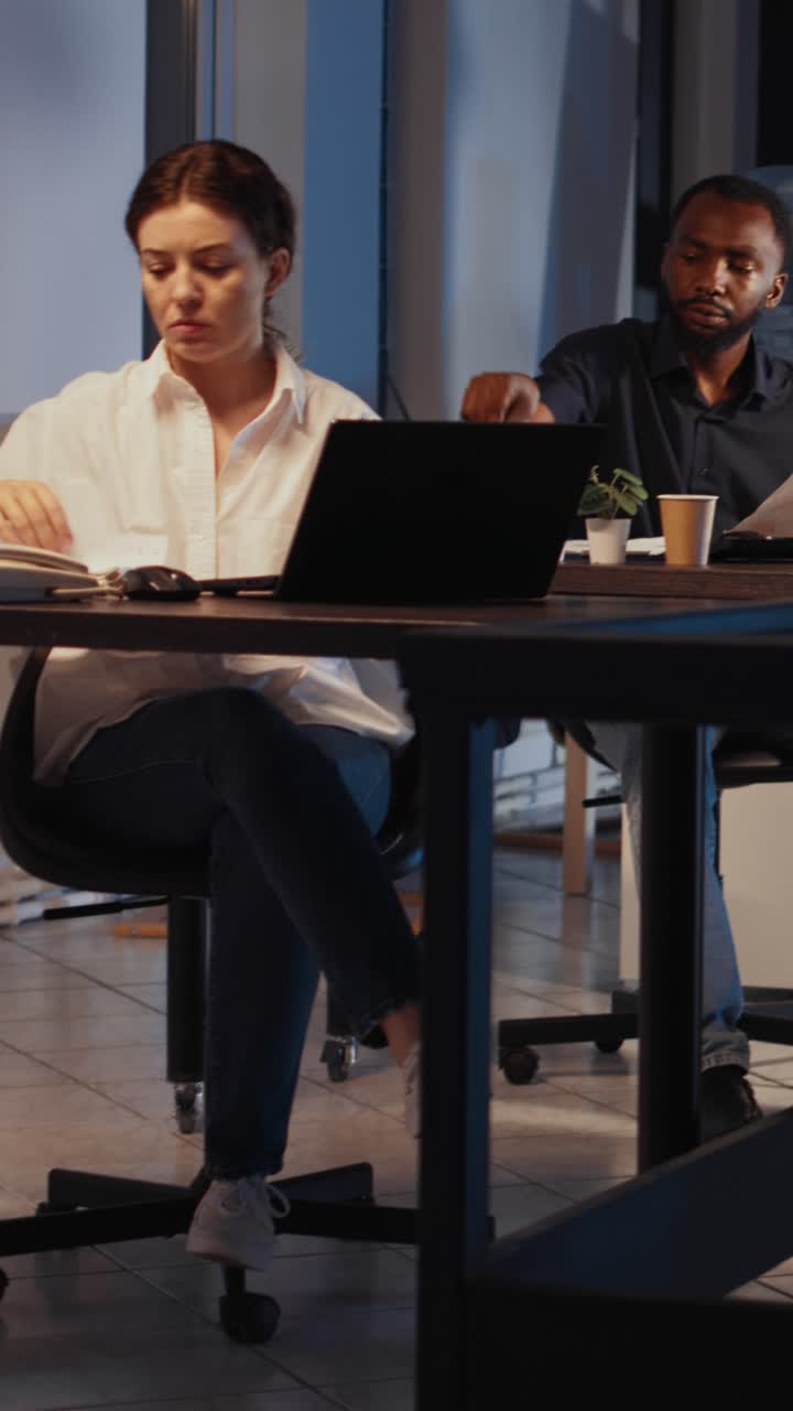 Video verticale: impiegati che lavorano a un report di startup fino a tardi