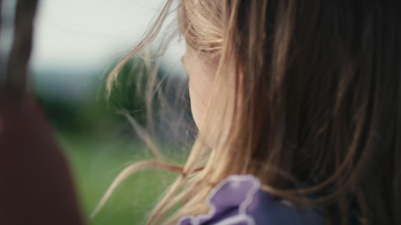 Close up of girl's hair in the wind swinging in summer day.