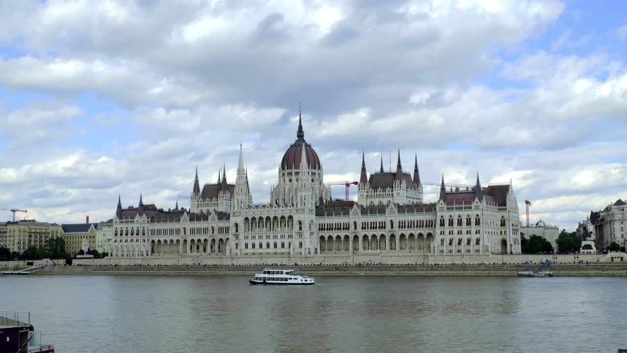 Hungarian Parliament Building And Ferry Cruising In Danube River In Budapest, Hungary. - wide shot