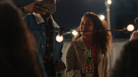 happy multiracial friends having fun dancing playfully together enjoying rooftop party at night laughing celebrating friendship