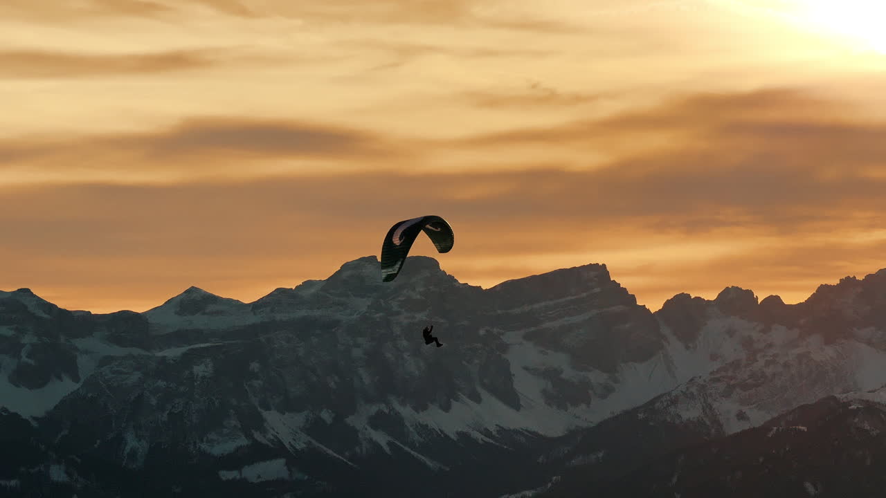 Paragliding over Snowy Mountains at Sunset