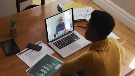 Afroamerikanische-Frau-Nutzt-Laptop-Bei-Videoanruf-Mit-Männlichem-Kollegen,-Der-Von-Zu-Hause-Aus-Arbeitet