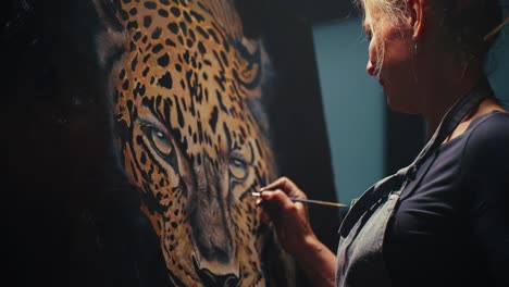 woman painting a leopard portrait in studio