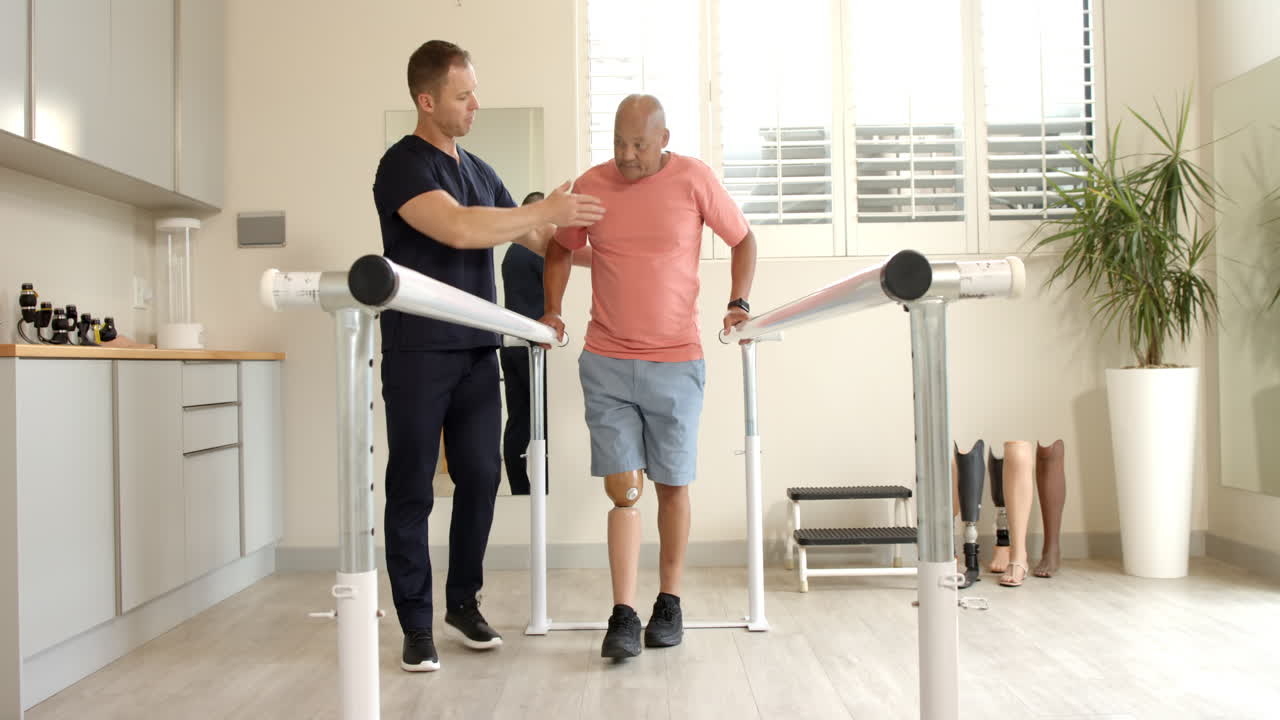 Therapist assisting man with prosthetic leg walking on parallel bars