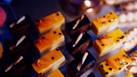 fruit and chocolate cakes and cupcakes in candy bar, top down view