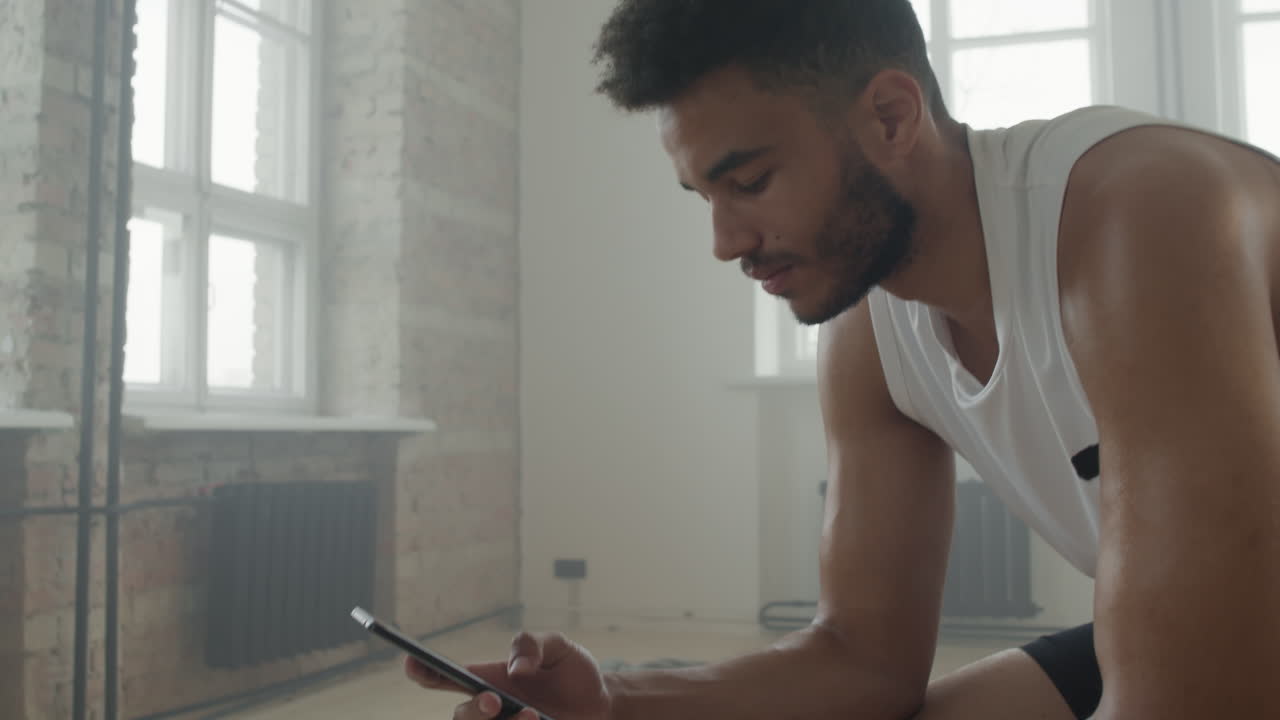 Sportsman Using Smartphone Between Sets