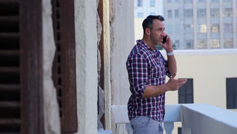 hombre hablando por teléfono móvil en el balcón 4k