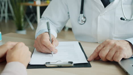 el médico discutiendo formularios médicos con el paciente