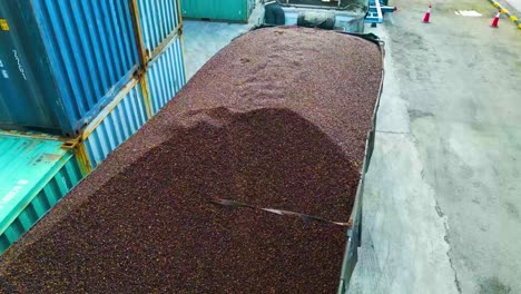 close up of palm kernel oil powder material loaded on a heavy-duty truck with cargo containers surroundings in a refinery oil factory, malaysia