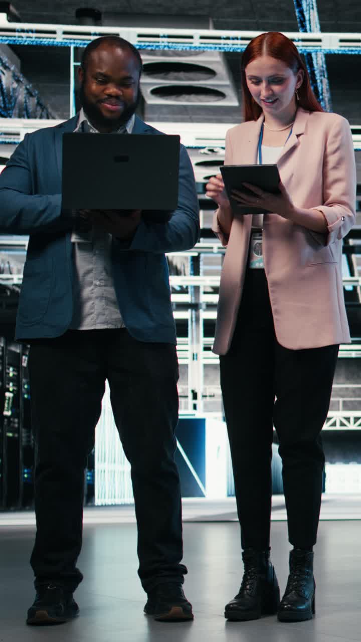 Vertical video Team of server farm software developers using laptop to optimize electronics