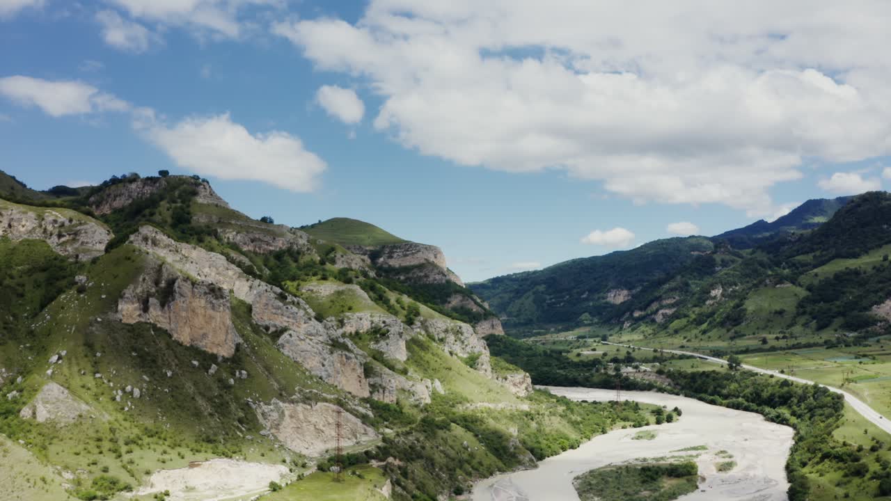 valle de montaña con río y nubes