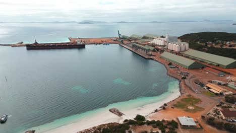 aerial view over esperance industrial harbour with a cargo ship beeing loaded, western australia