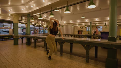joven bailarina contemporánea en el mercado urbano después de horas