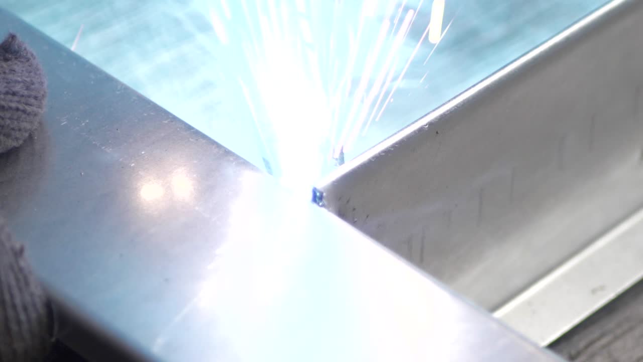 Welder works in metal construction - construction and processing of steel components, slow motion