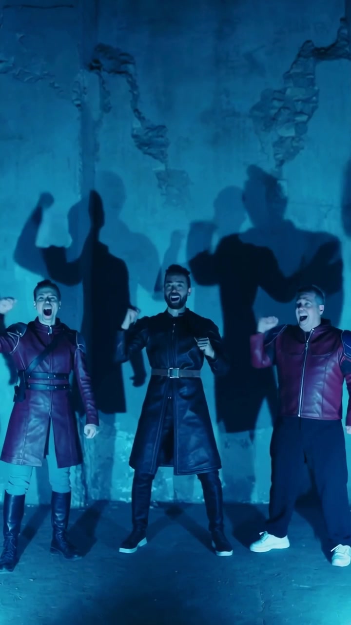 Vertical video: Reacting to cue, 3 men raising fists and shouting by cracked wall, leather coats