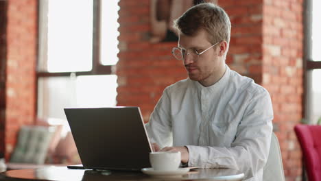 young freelancer man working on computer at home. casual concentrated entrepreneur developing