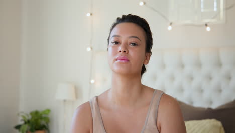 smiling woman relaxing in cozy bedroom with soft lighting and comfortable pillows