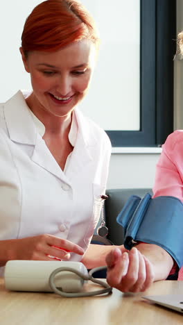 nurse checking blood pressure of senior patient